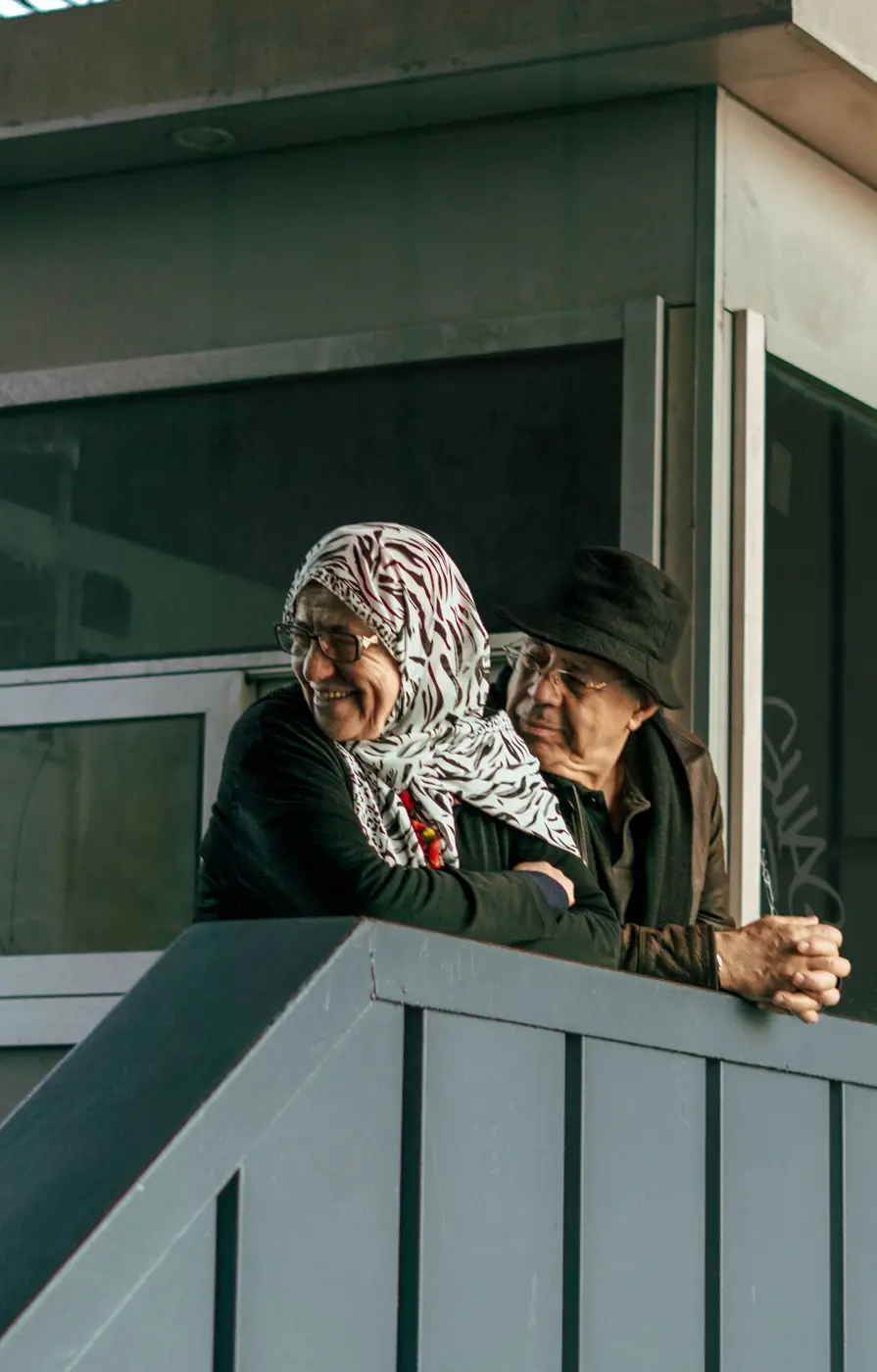 Older couple smiling together on the porch of their home