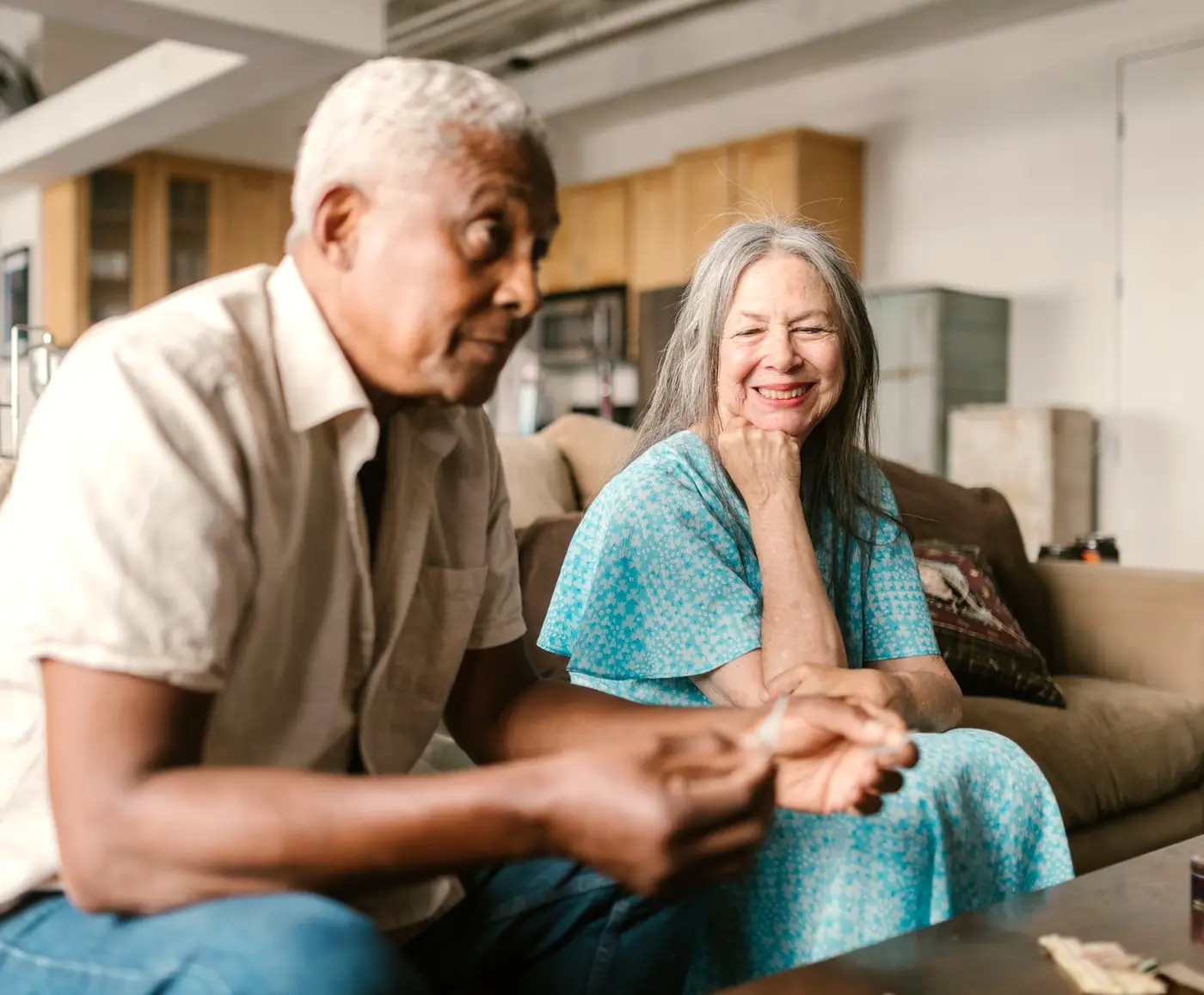 Happy older couple smiling together on the sofa at home